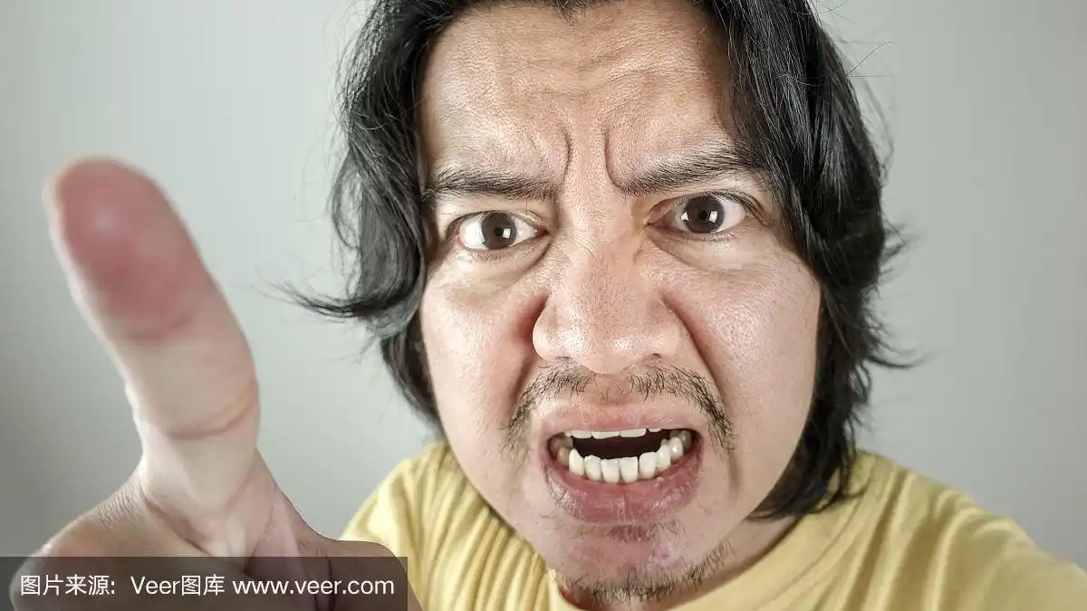 亚洲男人愤怒地指着白人背景.